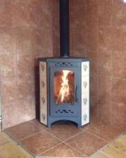 Недорогая печь-камин Бавария угловая с плитой незабудка Амазонка бай фото в интерьере в Орше
