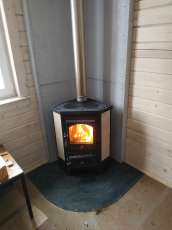 Недорогая печь-камин со стеклом Бавария угловая с плитой фото в интерьере в Орше